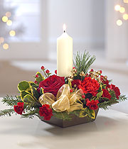 Christmas candle, with a white ribbon, red rose and an assortment of small red flowers