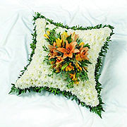 A floral cushion, white, orange open tulips at the centre