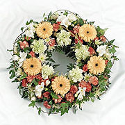 A large floral wreath, adorned with white, orange and red flowers