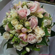 A bouquet of spray cream roses, Sedum, Freesia, pale pink roses and tulips