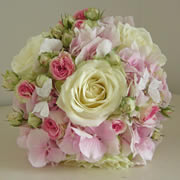 A bouquet of large ivory roses, small pink roses and pink Hydrangea